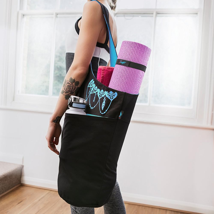 women standing wearing yoga on her shoulder black and blue filled with yoga accessories